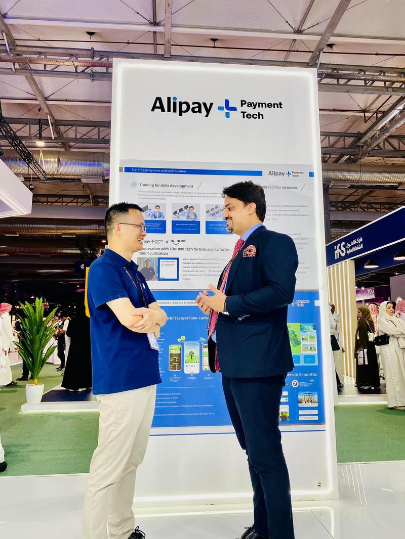 Ahmed Ali Larik in discussion at the Alipay Plus Payment Tech stand
